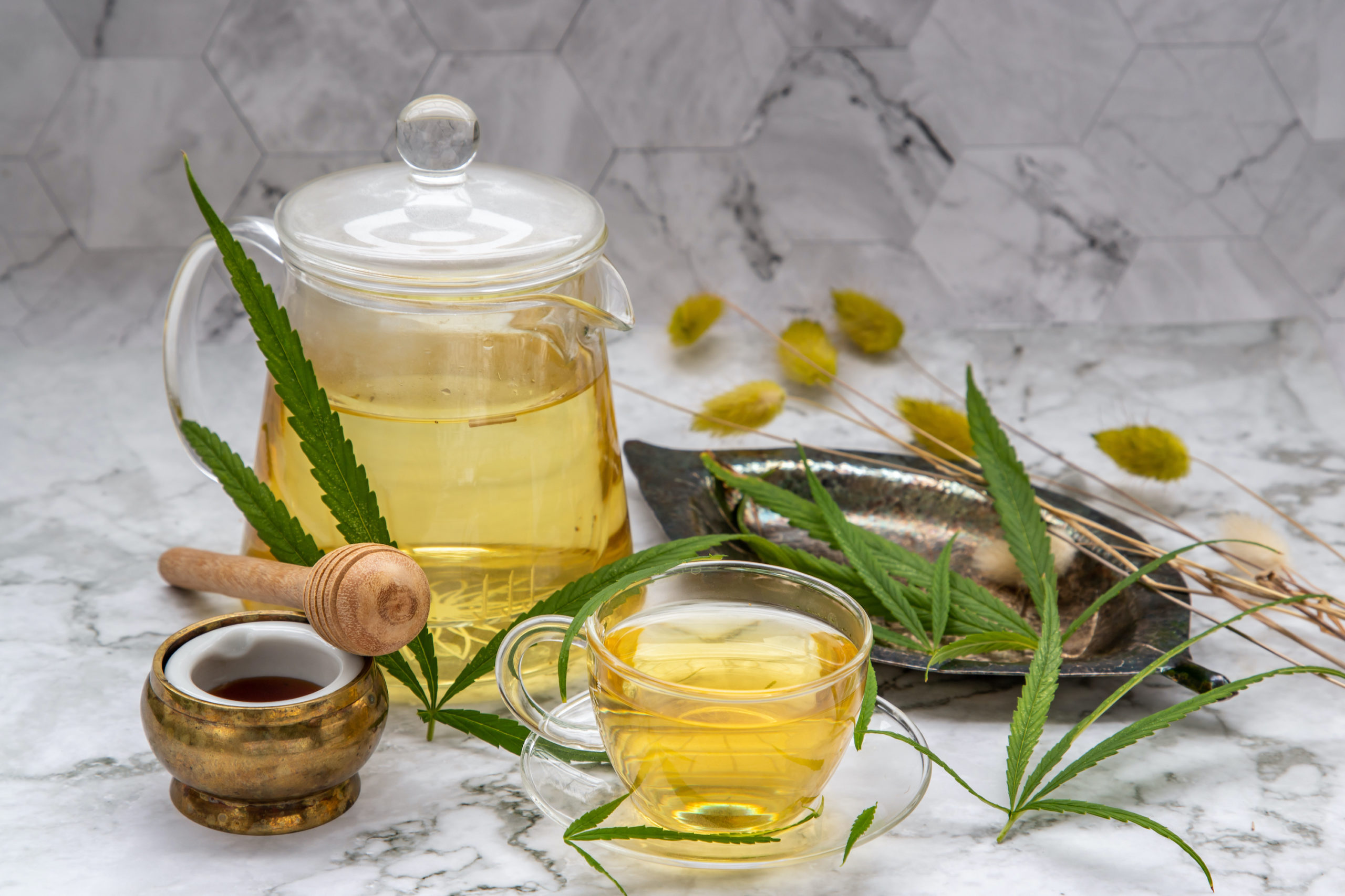 A cup of Cannabis herbal tea setup.