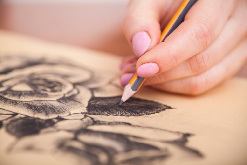 Closeup of woman's hands with a pencil drawing